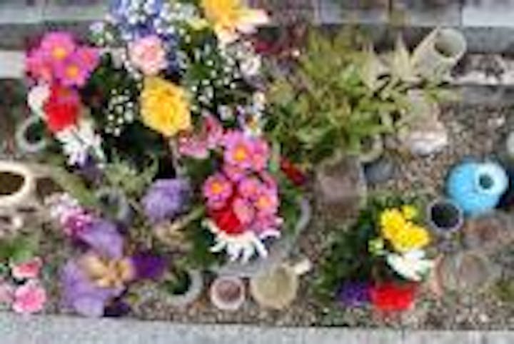 小さな墓石の下に、花々が手向けられていた