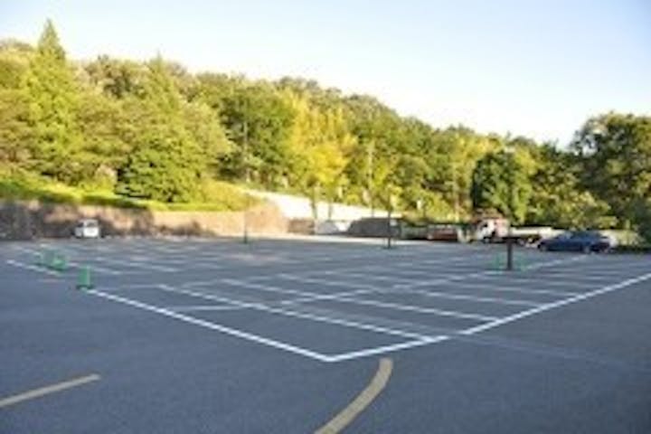 瑞谿殿の前に設けられた広大な駐車場。霊園奥の駐車場も含め233台収容。森の向こうは「こどもの国」。